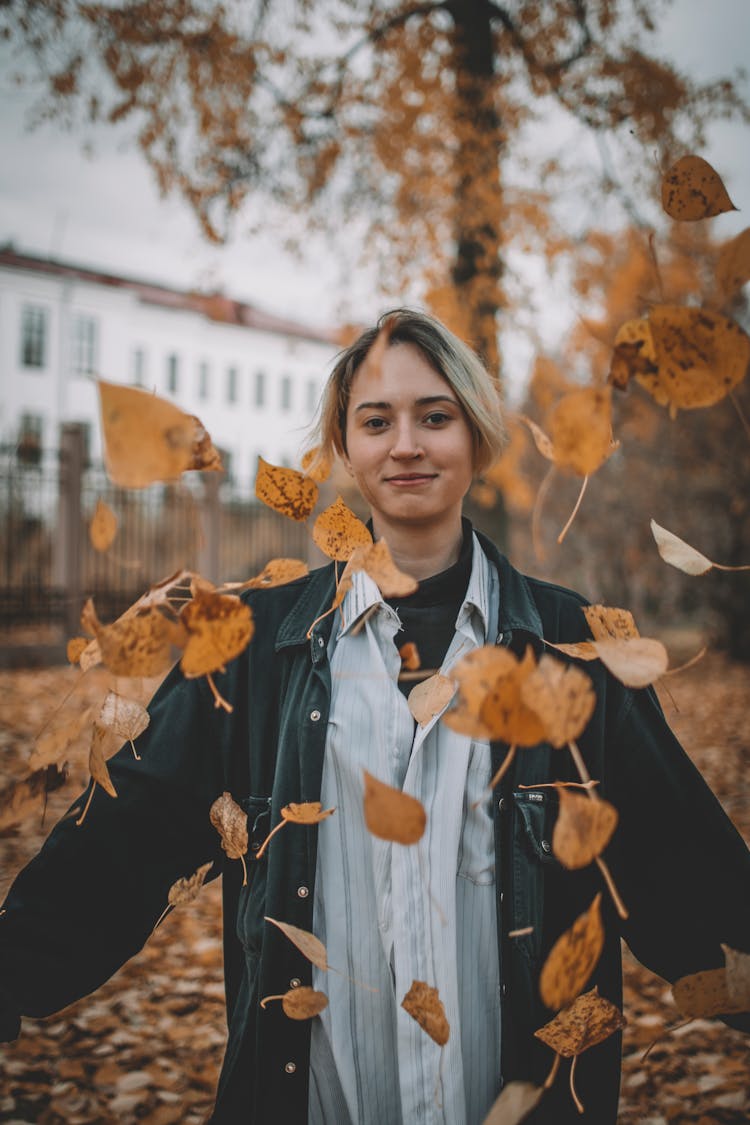 Young Woman Throwing Autumn Leaves 