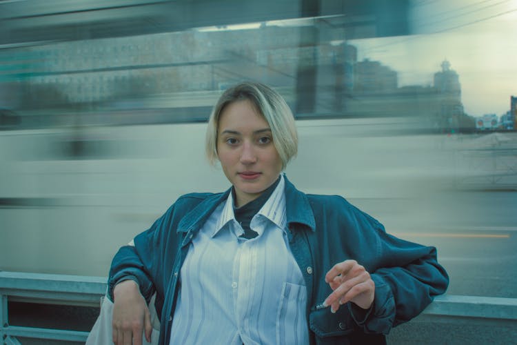 A Young Woman With Short Blonde Hair Near A Glass Window