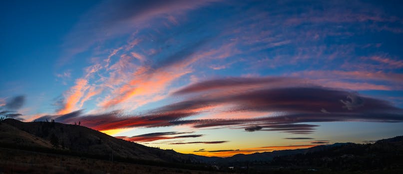 A breathtaking sunset with vibrant skies over a serene mountain landscape.