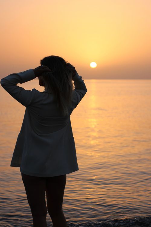 Woman Walking on Sea Shore at Sunset · Free Stock Photo