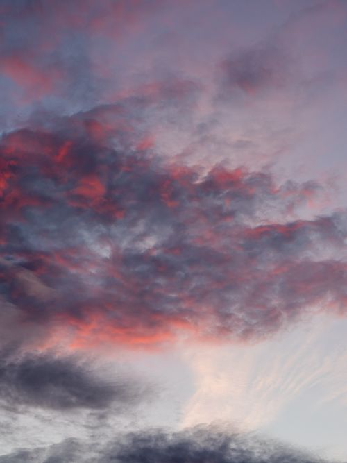 Free A stunning view of a colorful sky at sunset with dramatic pink and gray clouds. Stock Photo