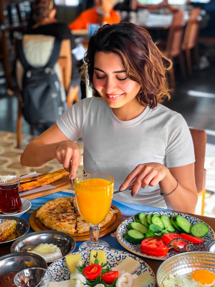 A Woman Slicing A Pizza