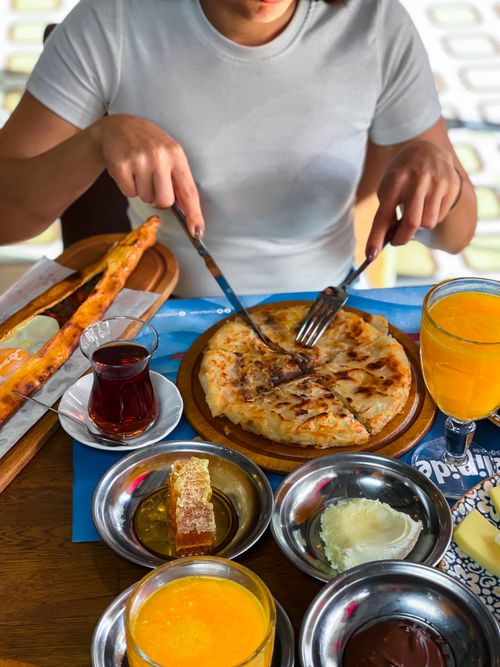 Free A person enjoying a diverse breakfast spread with orange juice, tea, and various dishes. Stock Photo