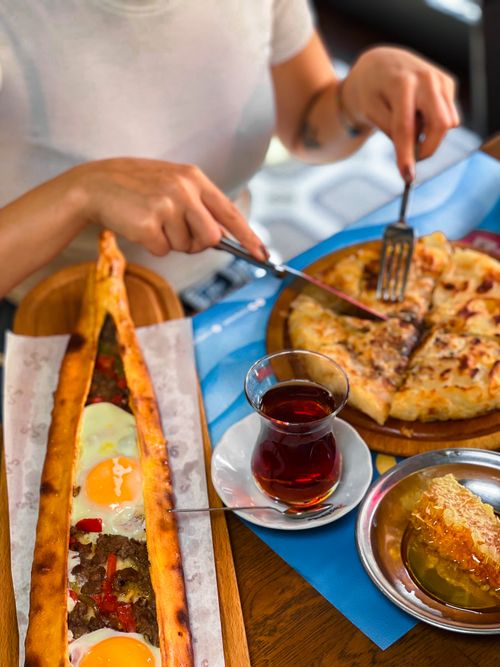 Free A vibrant Turkish breakfast spread featuring traditional pide, tea, and honey. Perfect for food enthusiasts. Stock Photo