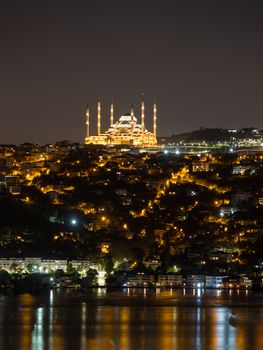 Stunning night view of Suleymaniye Mosque in Istanbul with illuminated minarets reflecting on Bosphorus waters.
