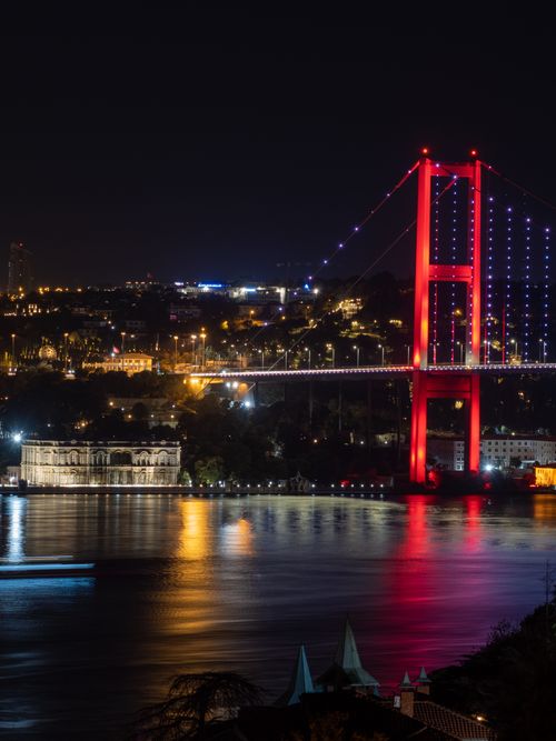 Free Dazzling view of the 15 July Martyrs Bridge glowing in vibrant colors over the Bosphorus at night. Stock Photo