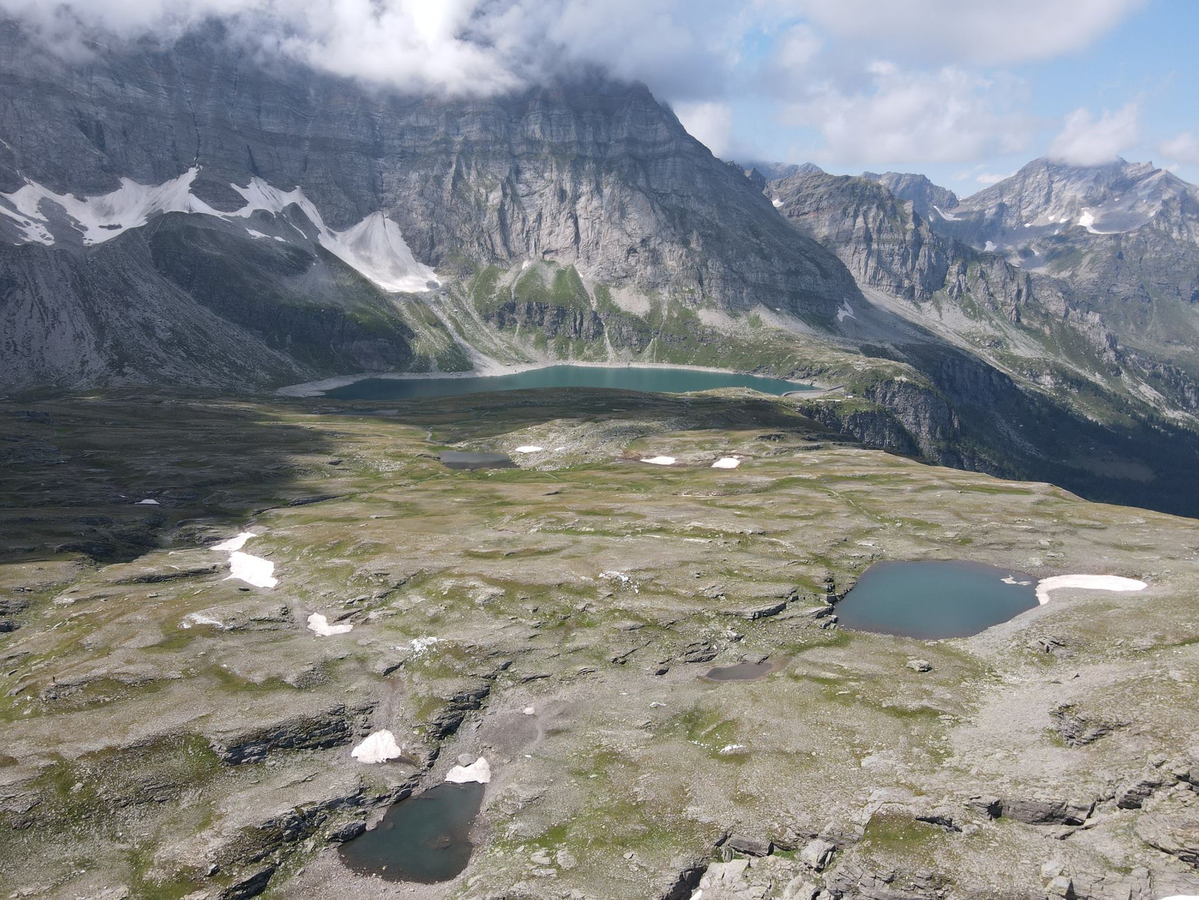 Stunning aerial view of alpine lakes and rugged mountains in Piemonte, Italy.