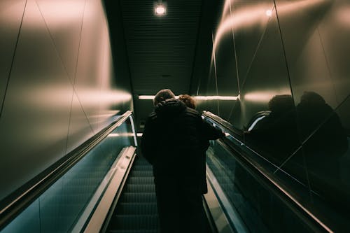 Person in Black Jacket Standing on Escalator