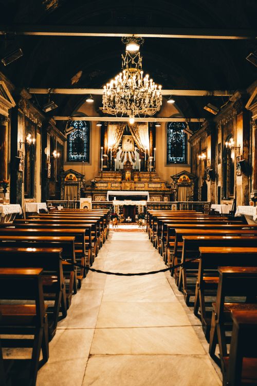 Free A beautifully decorated historic church interior with chandelier and pews. Stock Photo