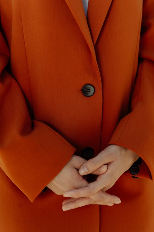 Interlocked Fingers of a Woman Wearing a Coat