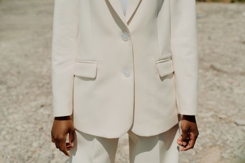 Free A fashionable adult wearing a stylish white suit under natural daylight conditions outdoors. Stock Photo