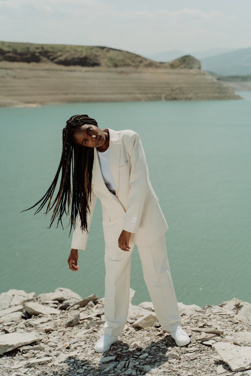 A Woman in White Suit Standing on Rocky Ground