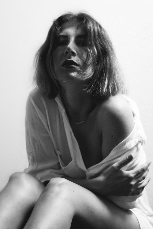 Free Stylish black and white portrait of a woman in a loose shirt, evoking a sense of intimacy and contemplation. Stock Photo