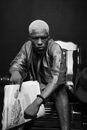 African American with white short hair sitting in chair and looking defiant