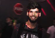 年轻人在色彩缤纷的聚光灯下微笑着享受夜总会的气氛