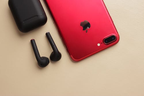 A Red Iphone Beside Airpods