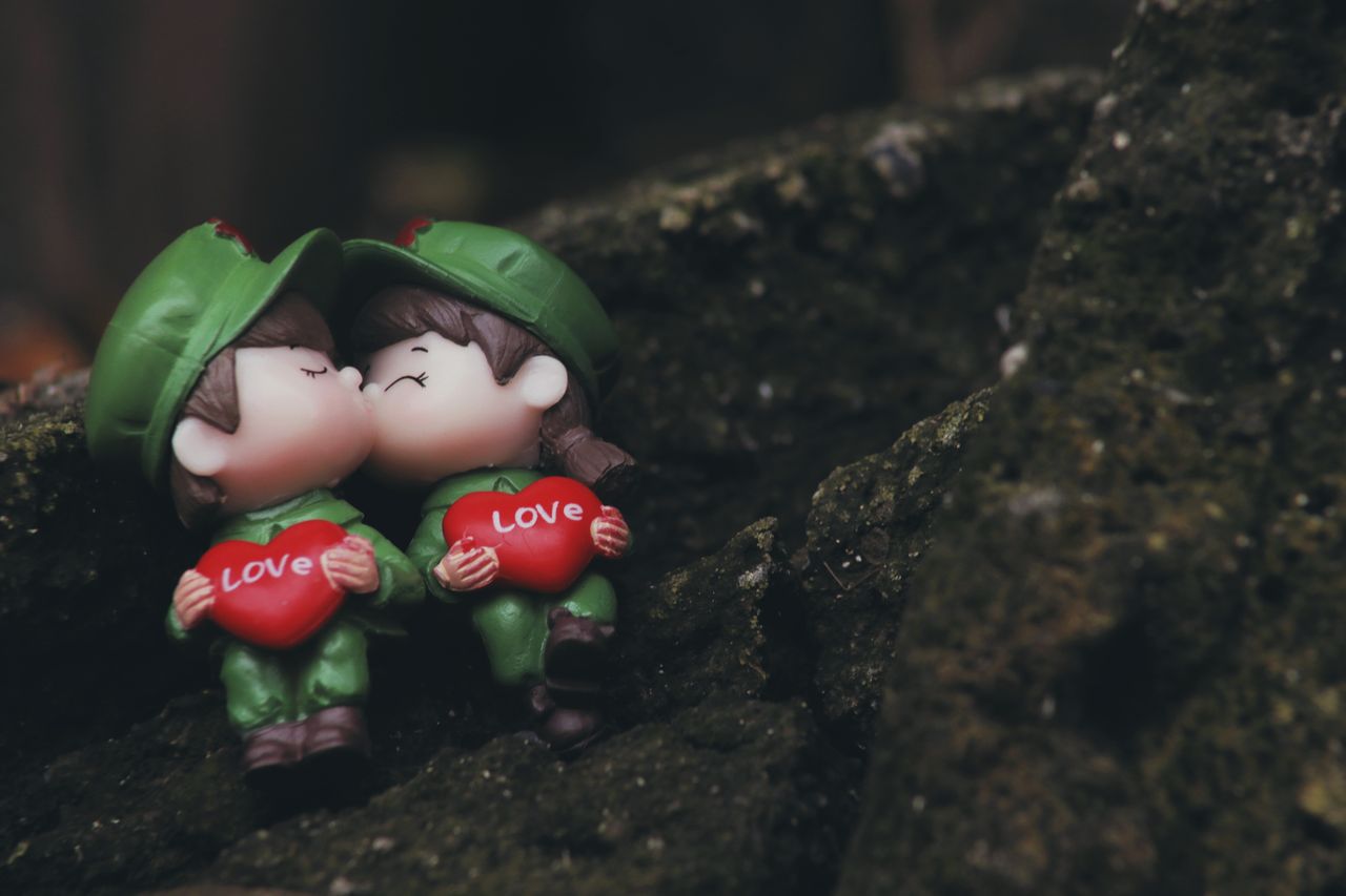 close up of toy soldier figures kissing with red heart labeled love on