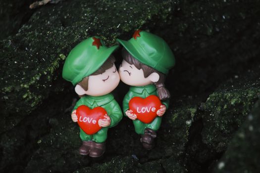 Two cute toy soldiers holding heart-shaped signs with 'love,' perfect for romantic or playful themes.