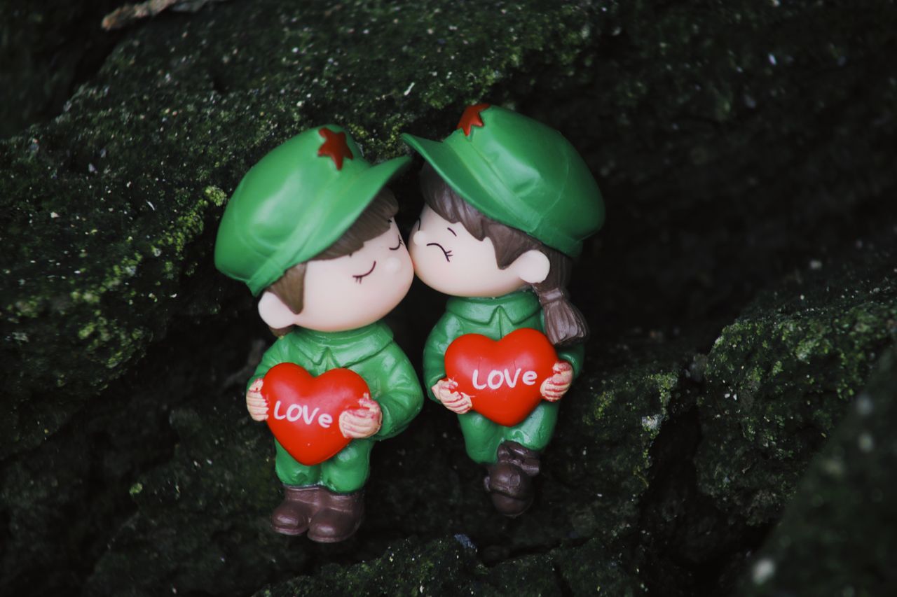 two cute toy soldiers holding heart shaped signs with love perfect for