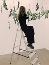 Woman Sitting on Tip of Ladder