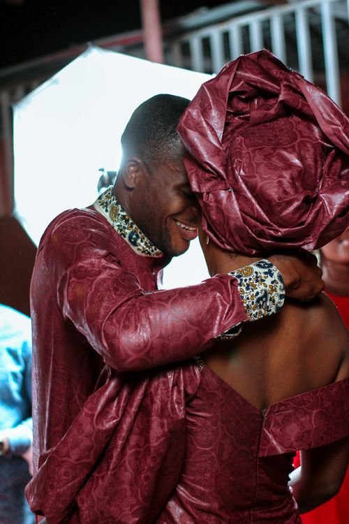 Free Happy African couple in vibrant traditional clothing embracing joyfully indoors. Stock Photo