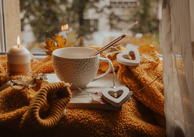 A Teacup Beside A Lighted Candle