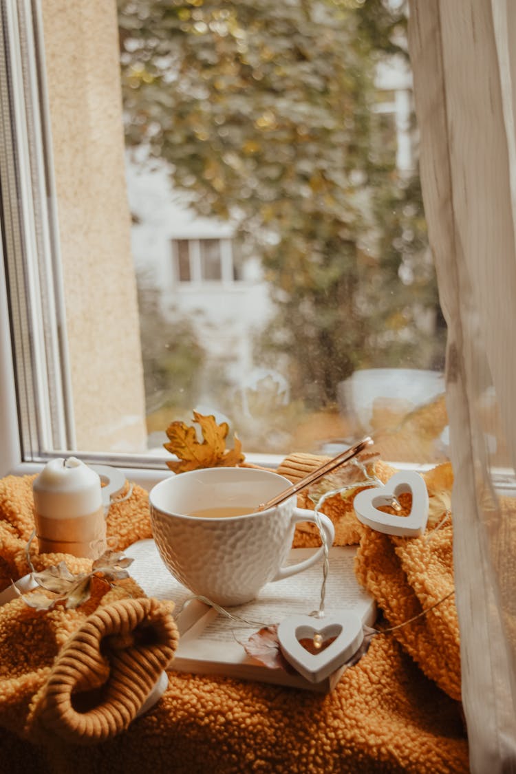 Teacup Beside A Candle On Round Table 