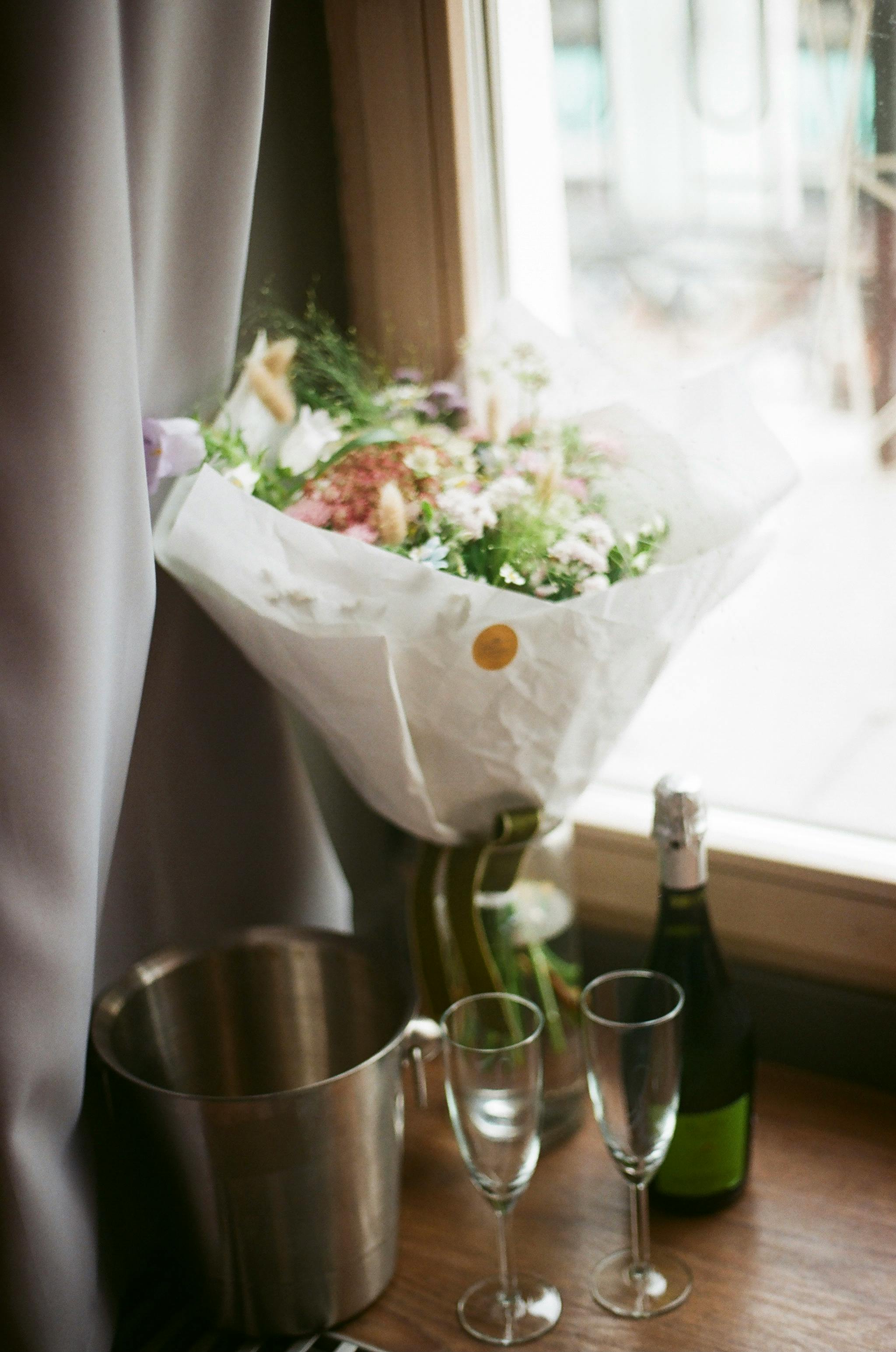 Luxury bouquet and champagne setting by the window for an elegant celebration.