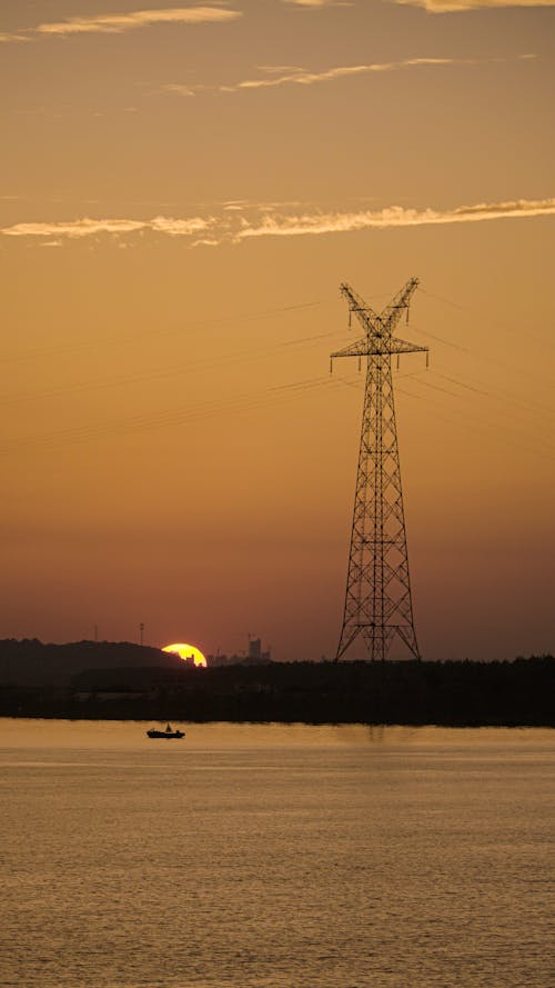 Silhouette of a Steel Transmission Tower during Sunset