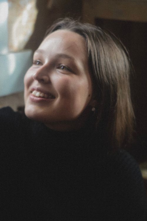 Free Close-up portrait of a young smiling woman indoors, exuding warmth and happiness. Stock Photo