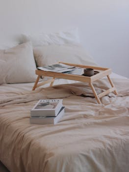 Books and bed table laying on double bed