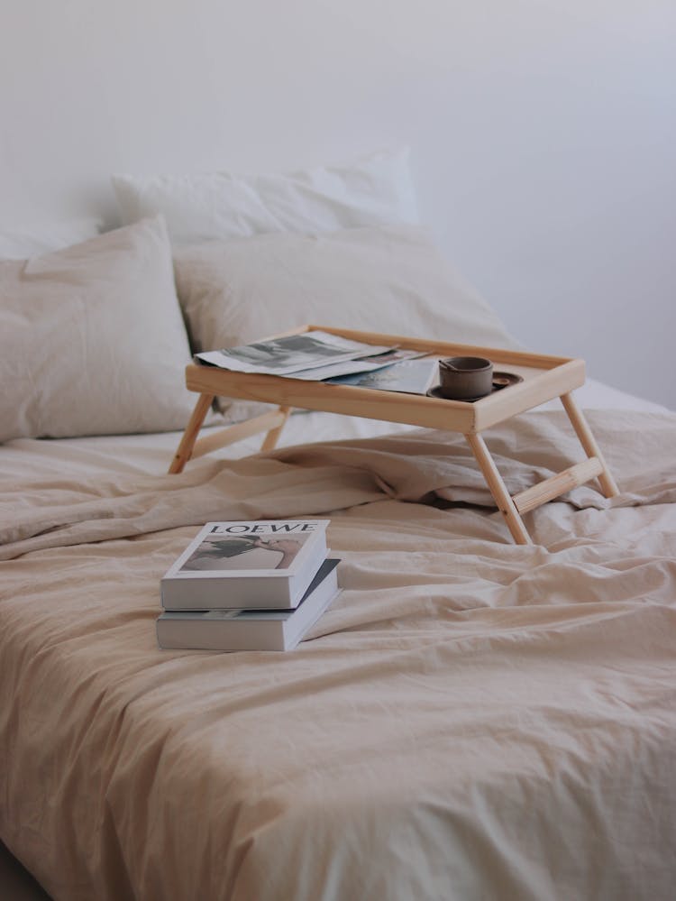 Books And Bed Table Laying On Double Bed