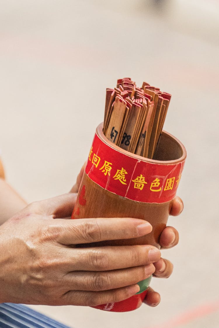 Unrecognizable Hands Holding Buddhist Fortune-telling Sticks 