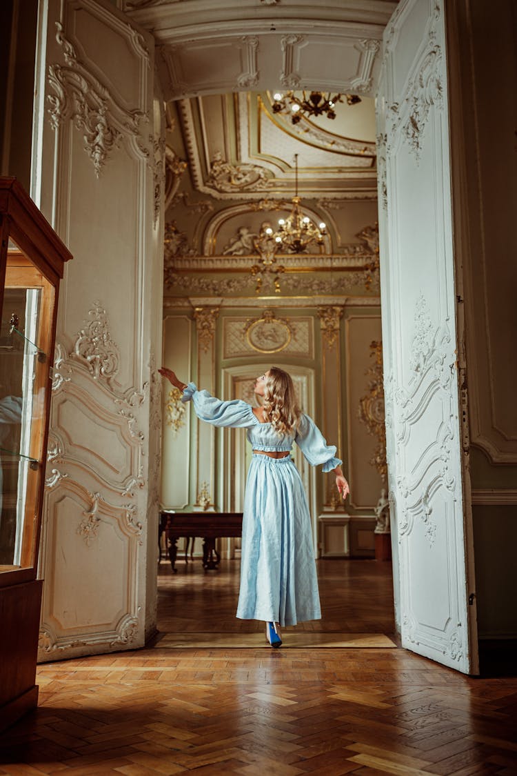 Woman Walking Through Ornate Door In A Hallway