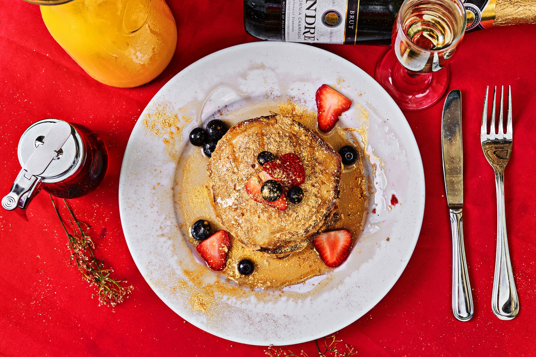 Fluffy pancakes served with berries and syrup at a lively breakfast spot