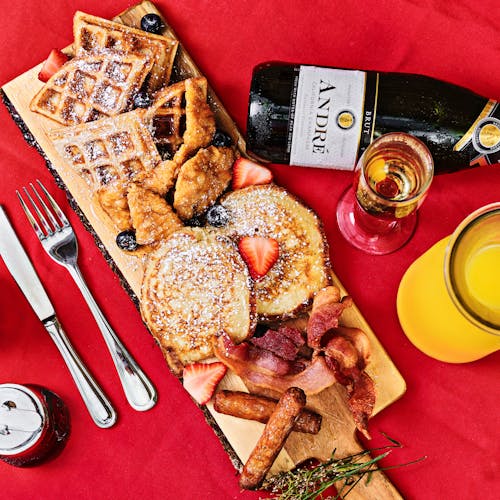 An Assorted Delicious Food on a Wooden Board with a Bottle of Wine