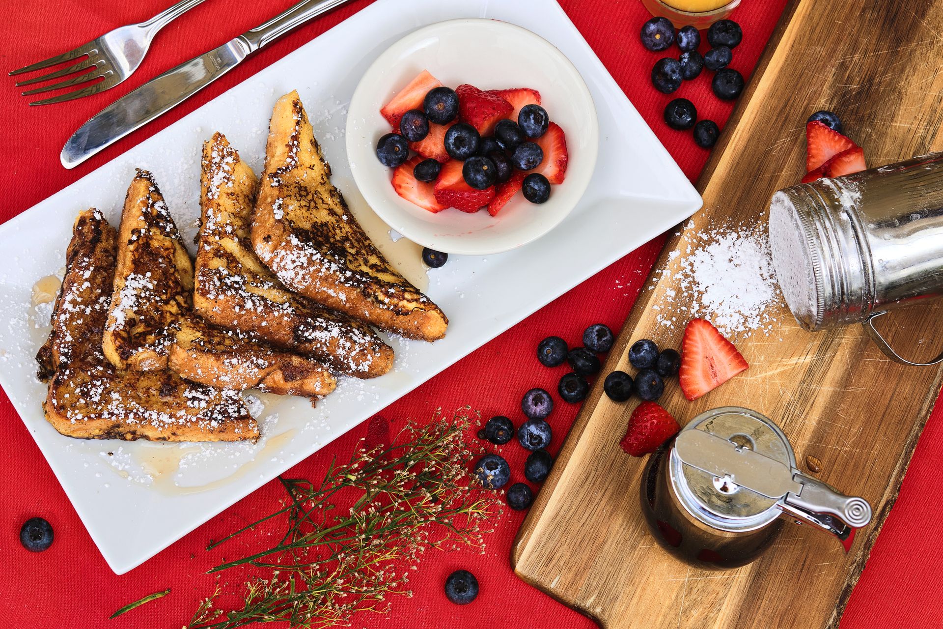 Delicious French toast topped with fresh blueberries and strawberries for a sweet breakfast treat.
