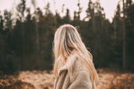 秋天，一名身穿外套的金发女子站在森林中，被人从身后抓住