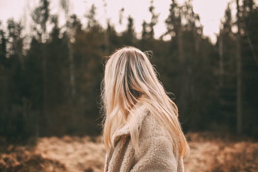 秋天，一名身穿外套的金发女子站在森林中，被人从身后抓住