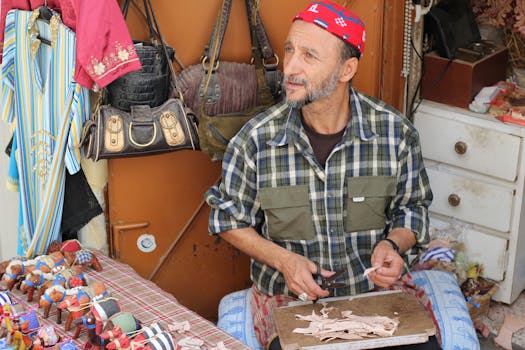 A skilled artisan crafting goods at a market stall in Tangier, Morocco.