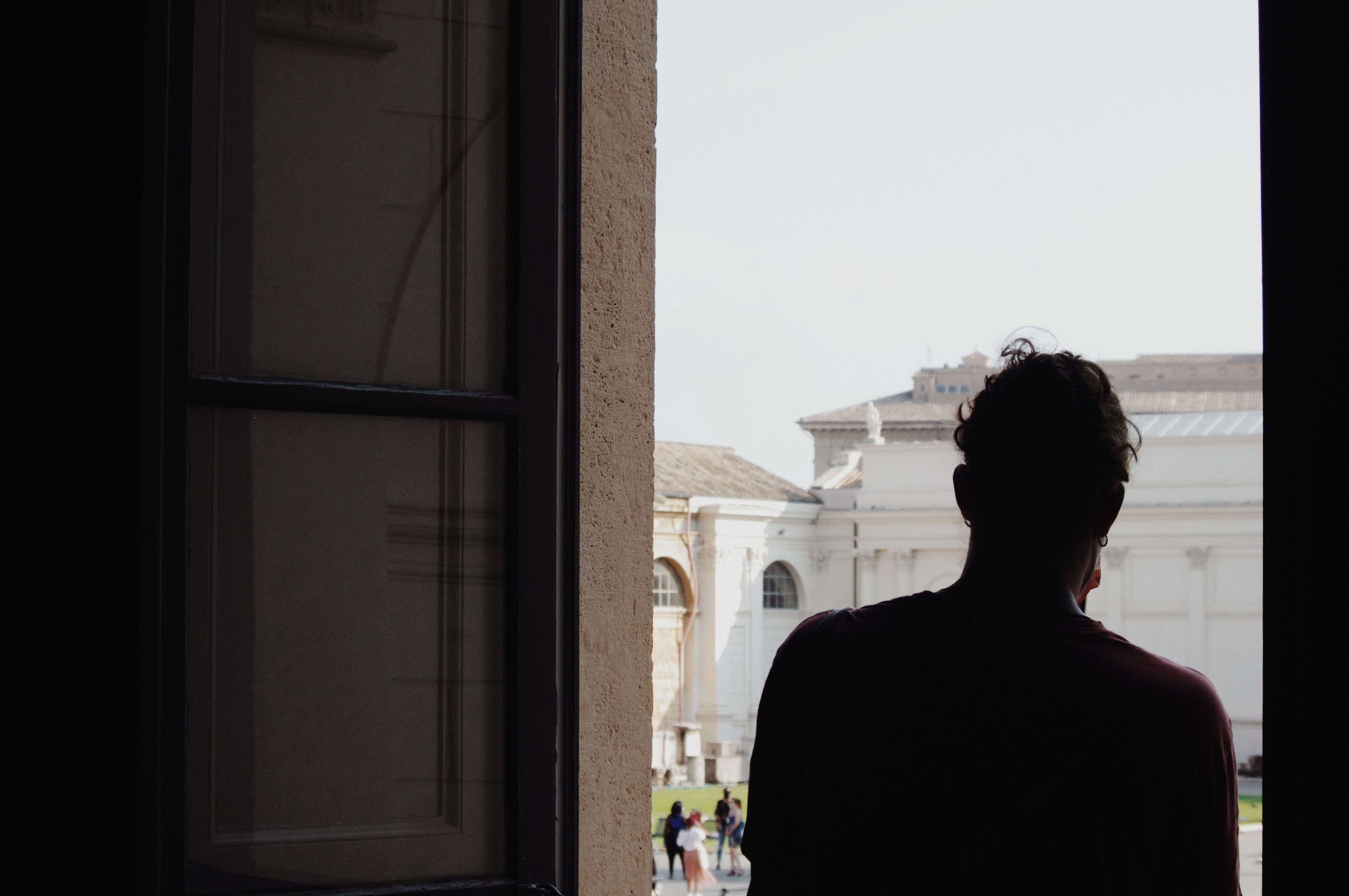 Man Inside a Building with Brown Door · Free Stock Photo