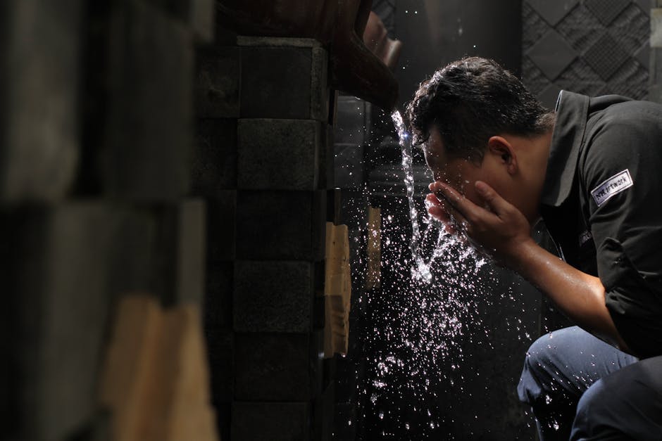 Man in Black Shirt Washing His Face