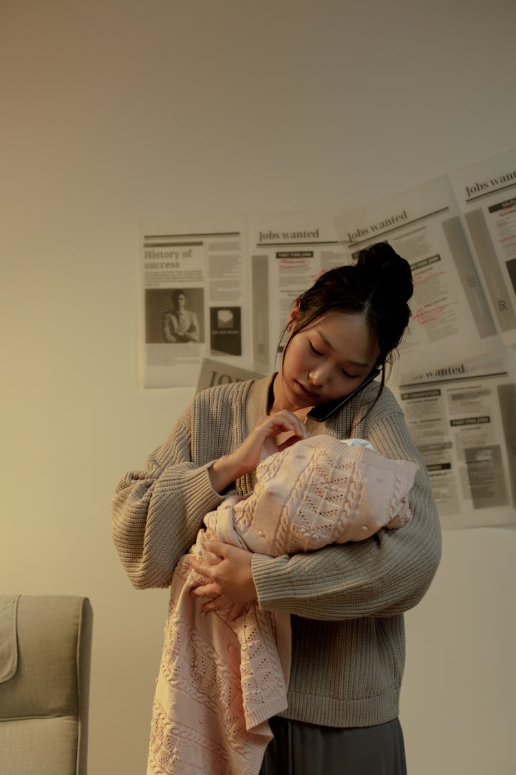 Woman Holding Newborn Baby In Hands And Touching It