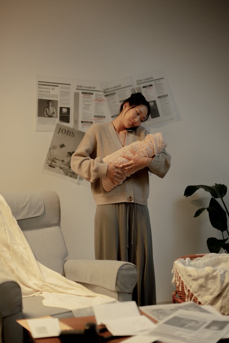 Woman Holding Newborn Baby In Hands