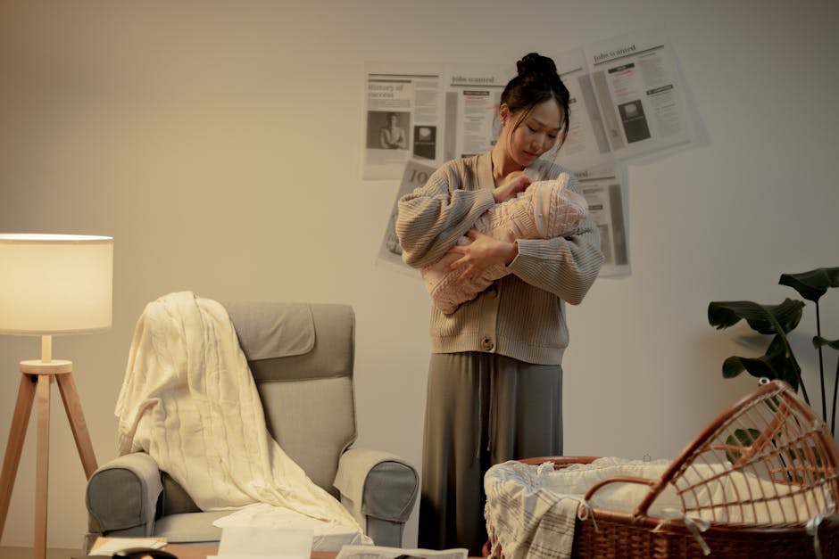 Hatch Rest vs Yogasleep Dohm: White Noise Showdown for Better Nursery Sleep A mother lovingly cradles her newborn in a cozy living room, evoking warmth and care.