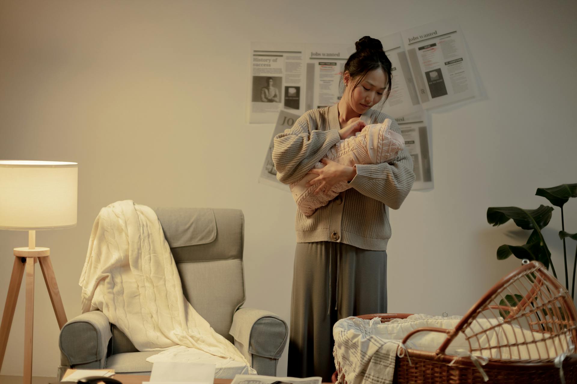 Woman Holding Newborn Baby in Hands and Looking at it