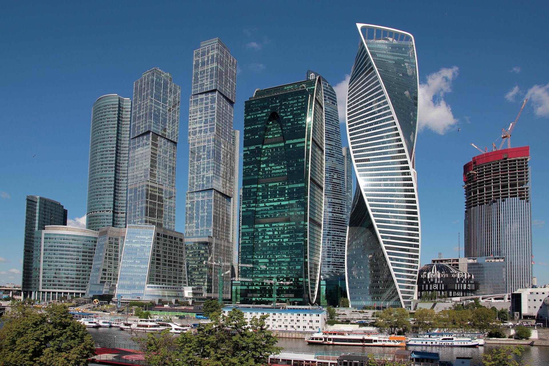 Panoramic view of modern skyscrapers in Moscow City under a clear blue sky.