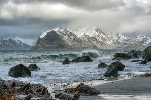 Free Captivating winter seascape of snow-covered mountains and stormy seas in Nordland, Norway. Stock Photo