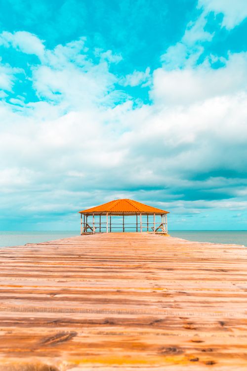 Free A serene seaside gazebo on a wooden pier in the Dominican Republic, perfect for a tropical escape. Stock Photo