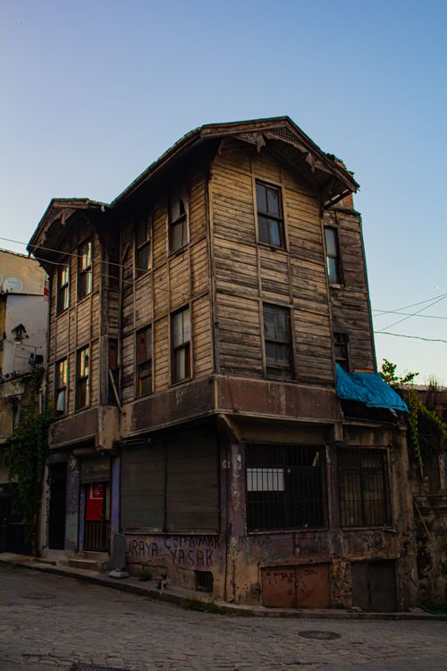 Free A rustic, abandoned wooden house on a quiet urban street. Low angle view. Stock Photo